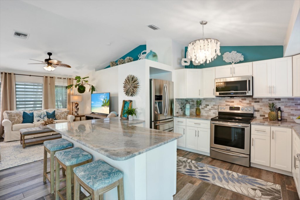 Open-concept kitchen and living area with modern appliances and cozy seating.