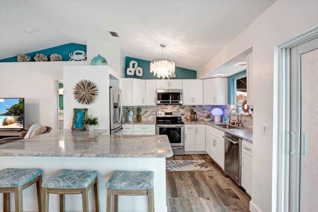 Modern kitchen with marble countertops and bar seating, perfect for entertaining.