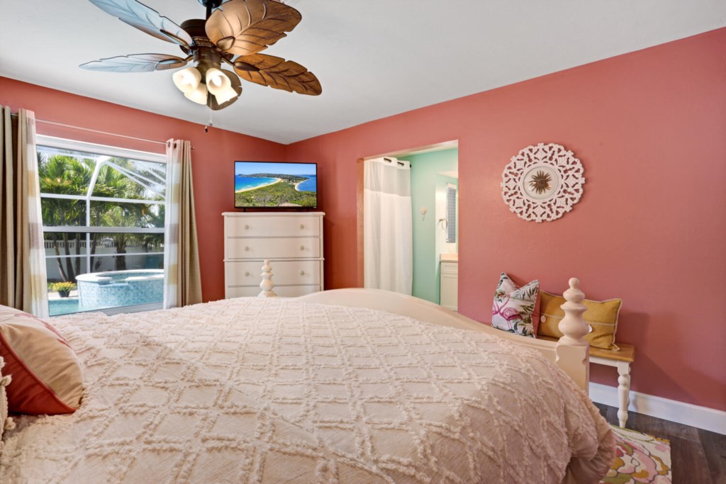 Charming bedroom with pool view, cozy bedding, and tropical decor for a relaxing retreat.