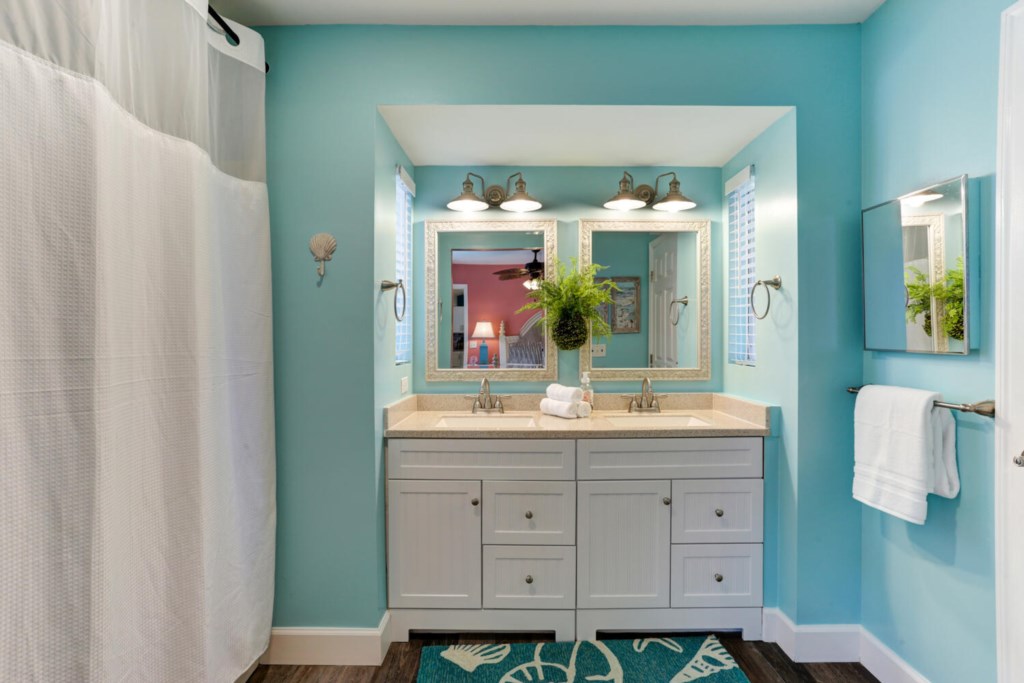Bright bathroom with double sinks, fresh towels, and coastal decor.