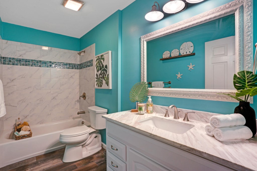 Bright bathroom with ocean-themed decor and a spacious vanity.