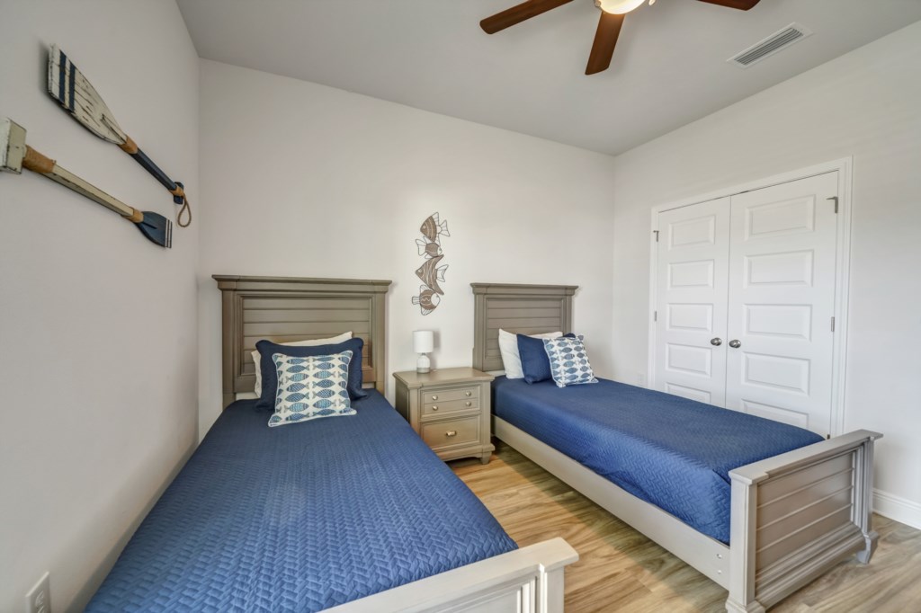 The third guest bedroom features 2 twin beds, ceiling fan, and television 
