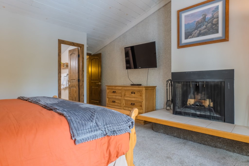 Main Bedroom: King bed, wood burning fireplace, and en suite bathroom.