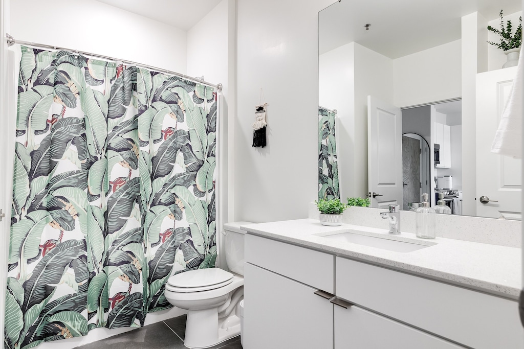 Modern bathroom which includes shower essentials like body wash, shampoo, and conditioner. 