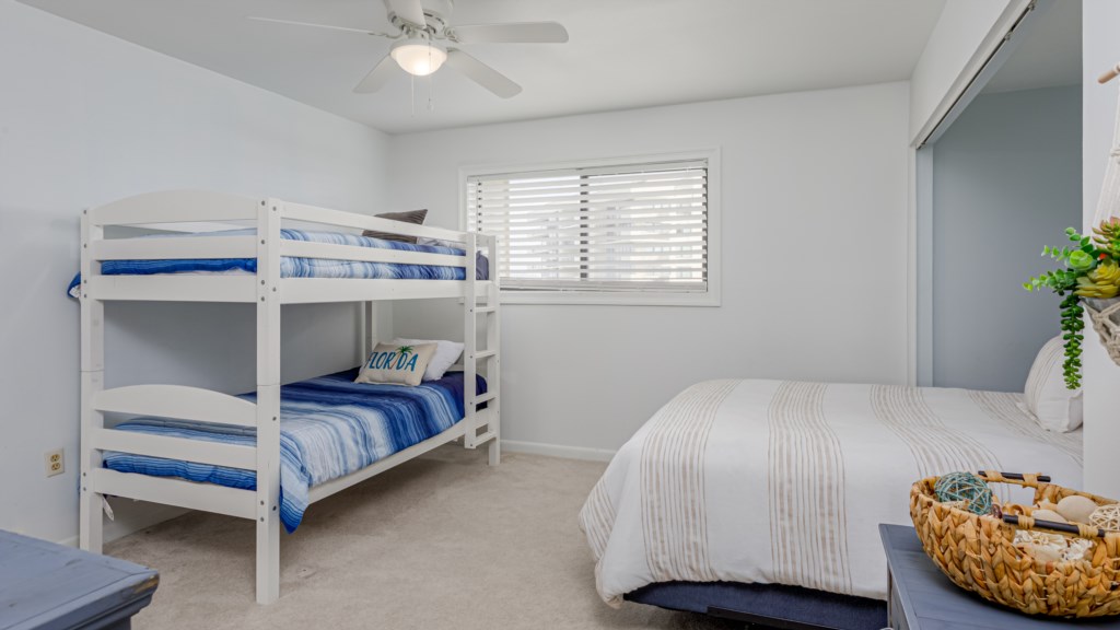 The second bedroom offers twin over twin bunk beds and an additional queen size bed