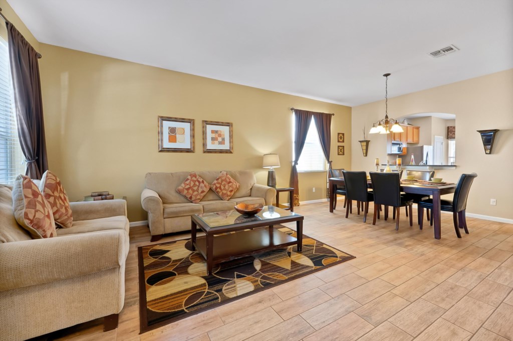Open-concept living and dining area with cozy seating and elegant dining table.