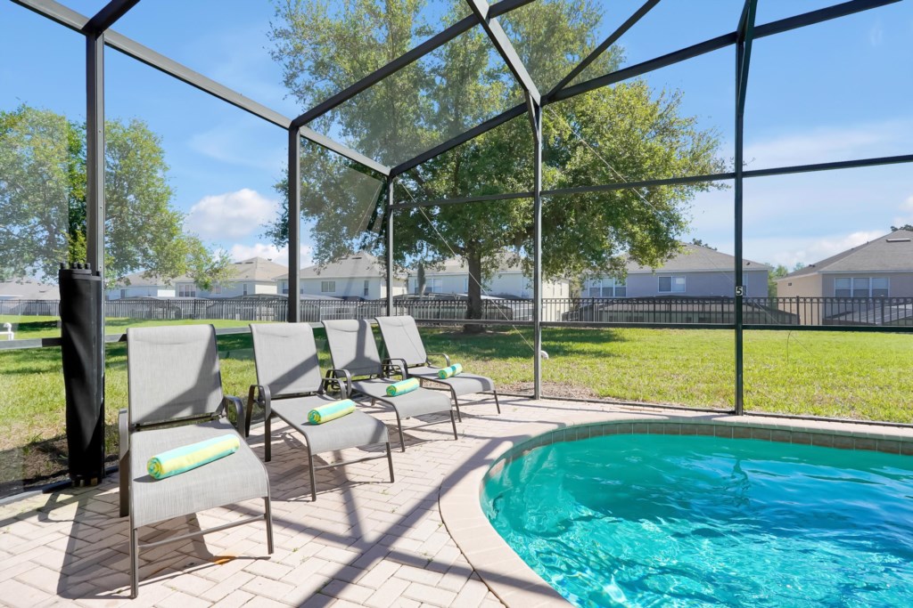 Relax by the private screened pool with comfortable loungers and serene garden views.
