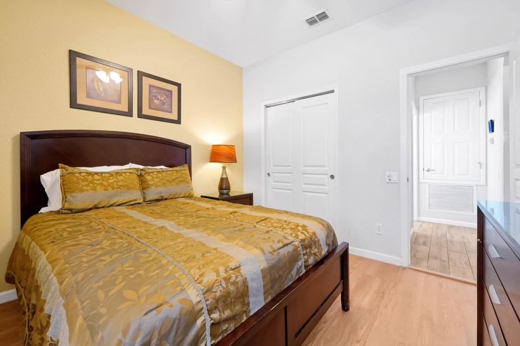 Cozy bedroom with elegant bedding and warm lighting for a relaxing stay.