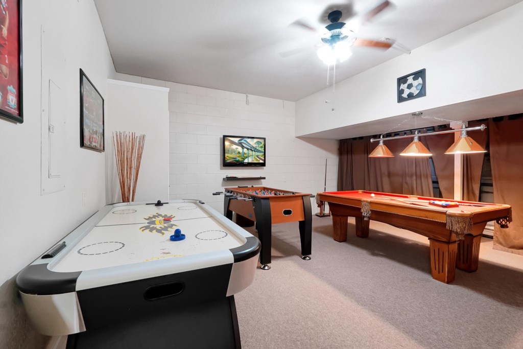 Fun game room with air hockey, foosball, and pool table for endless entertainment.
