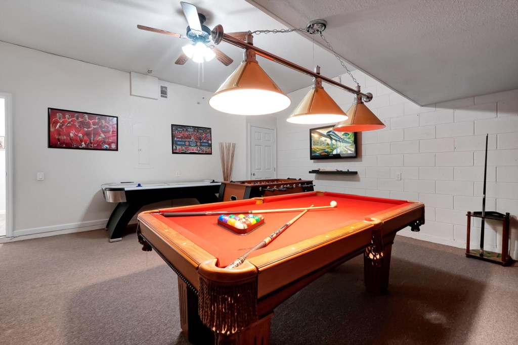 Game room with pool table, air hockey, and foosball for endless fun.