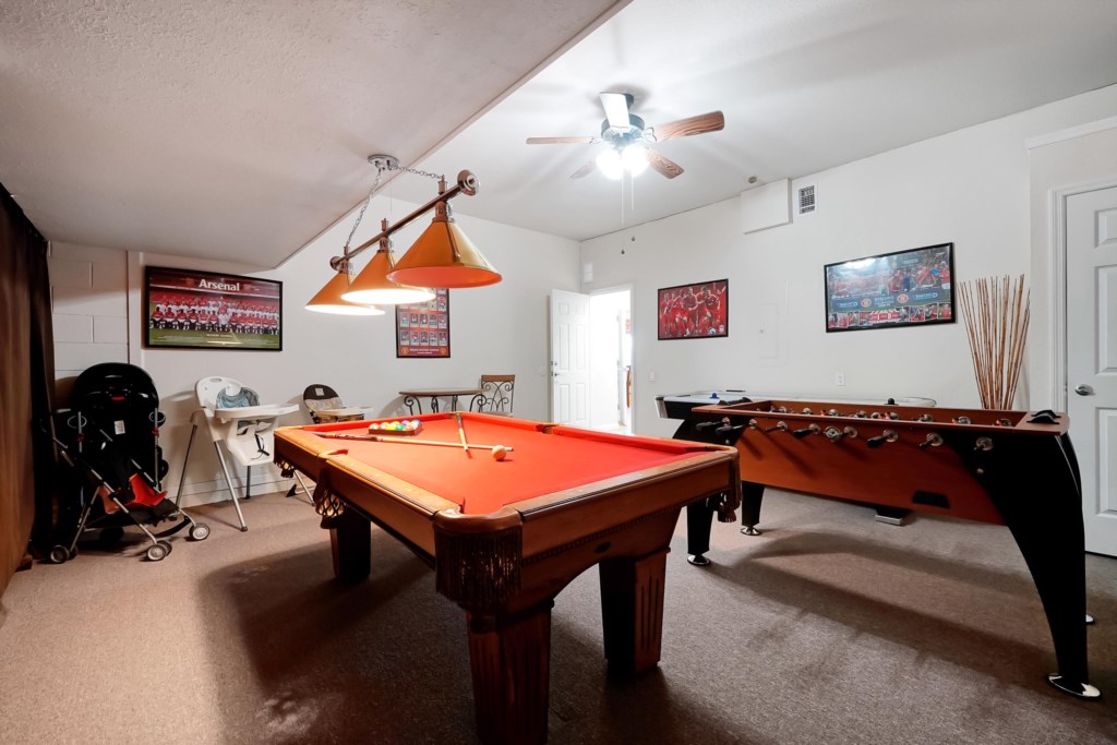 Game room with pool table and foosball, perfect for family fun and friendly competitions.