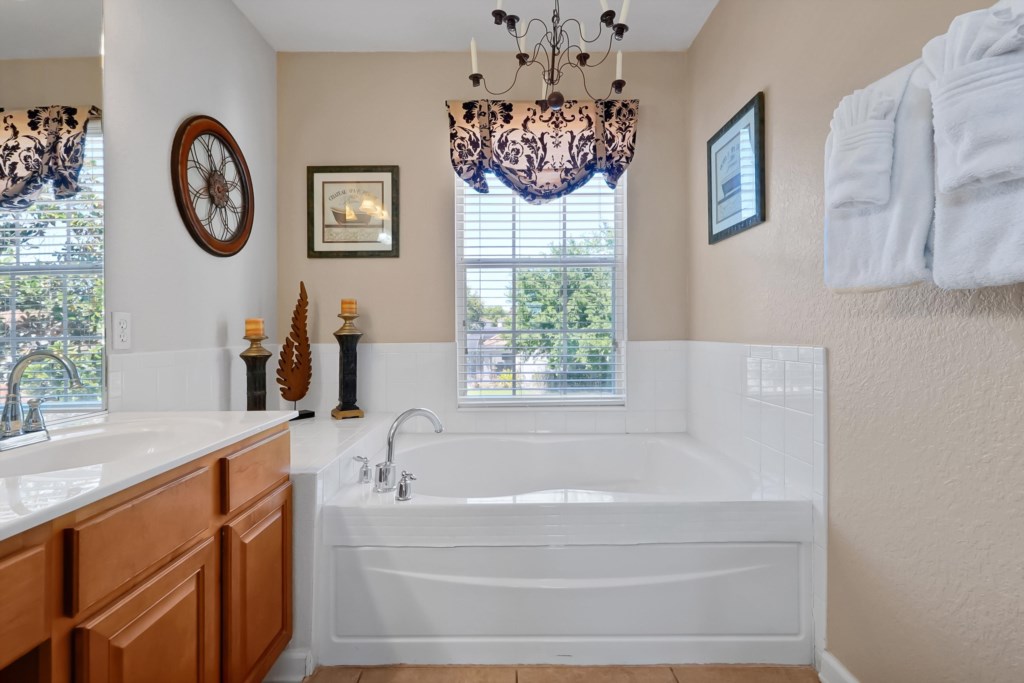 Relaxing bathroom with a spacious soaking tub and natural light from large windows.
