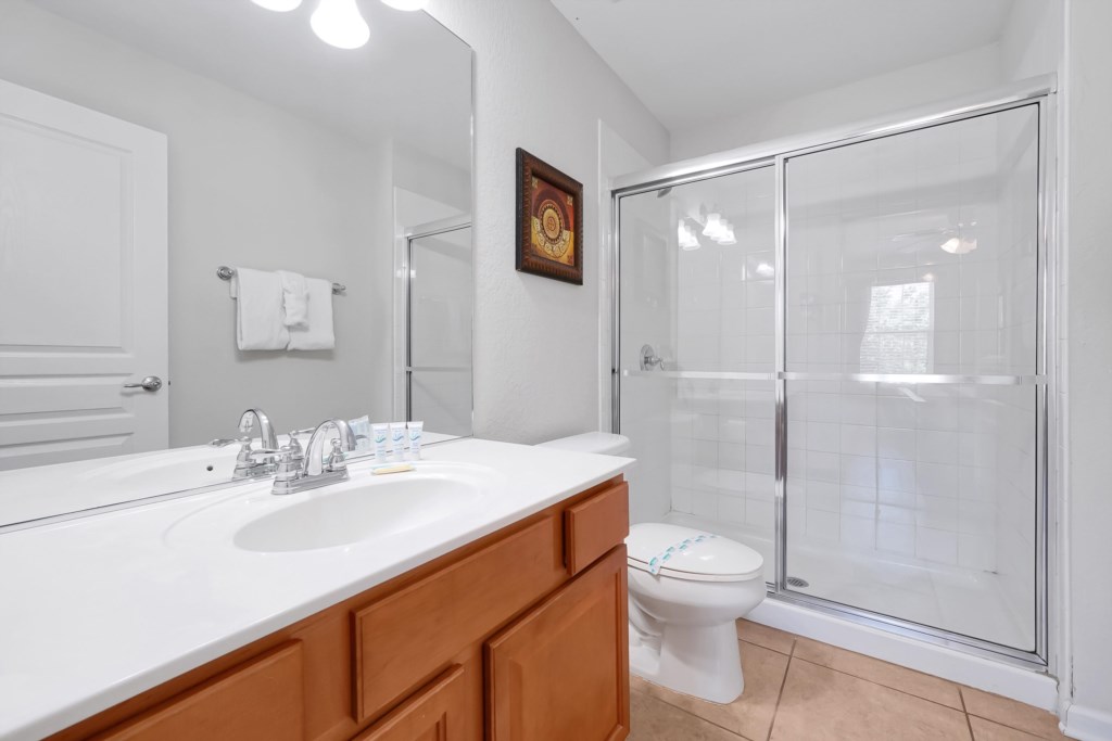 Modern bathroom with  vanity and a spacious glass-enclosed shower.