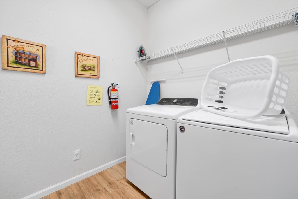 Convenient laundry room with washer, dryer, and ample shelving for your essentials.