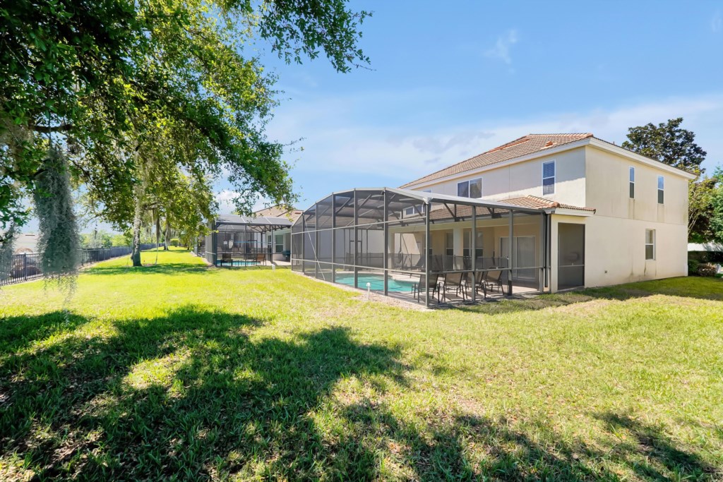 Spacious backyard with screened pool area, perfect for outdoor relaxation and family gatherings.