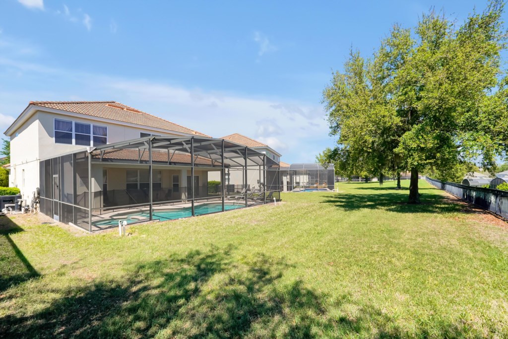 Spacious backyard with screened pool area, perfect for outdoor relaxation and family fun.