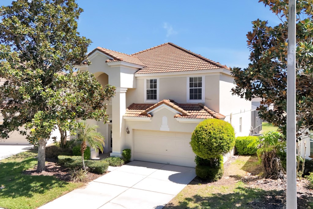 Charming villa with a tiled roof and lush landscaping, perfect for a relaxing getaway.