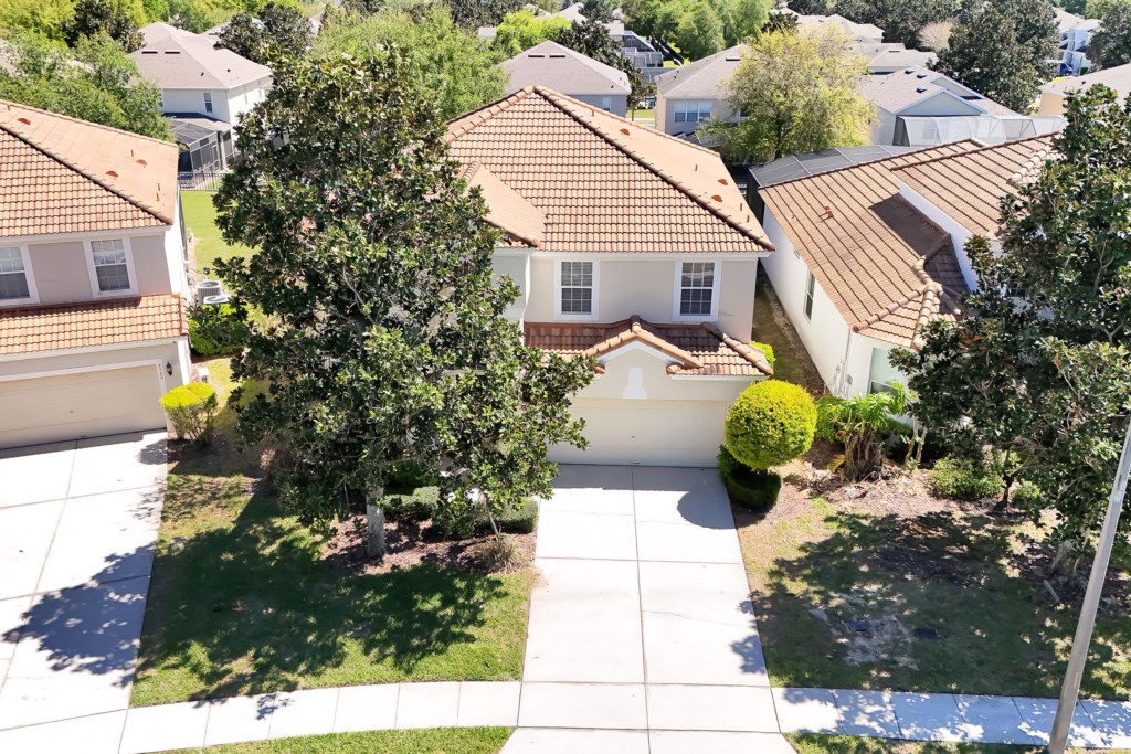 Charming two-story home with a spacious driveway and lush greenery.