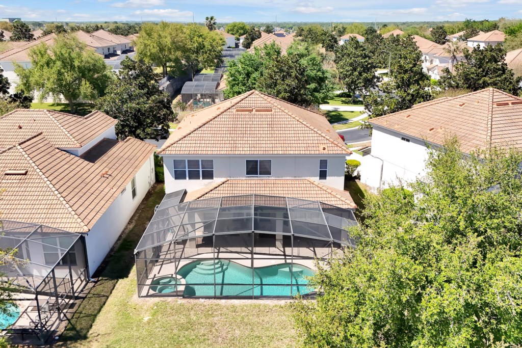 Spacious backyard with a private screened pool, perfect for relaxing in the sun.