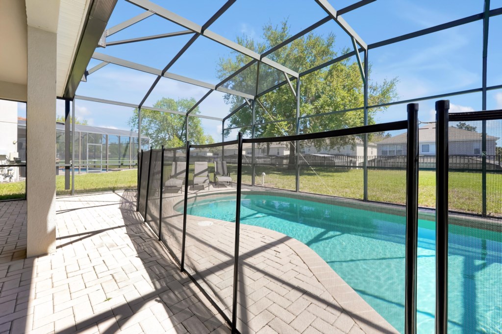 Private screened pool area with safety fence, perfect for family relaxation and sunbathing.