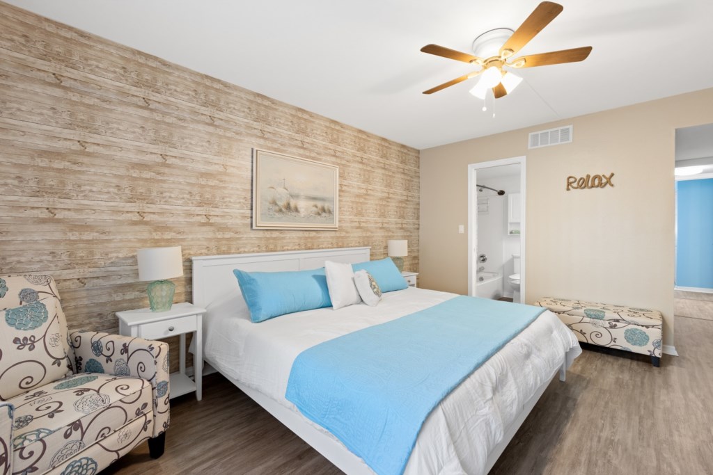 Relaxing master bedroom with coastal decor and en suite access.