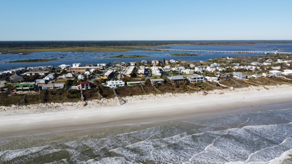 Aerial view of beachfront properties with easy access to sandy shores.