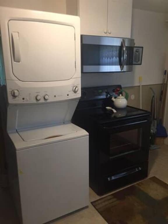 Stack Washer/Dryer is in the kitchen next to the electric range & microwave.