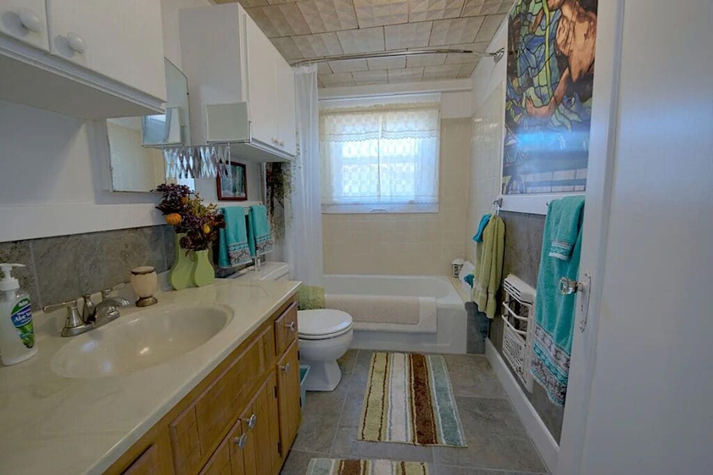 Bathroom with Tub/Shower, & Mural of ceiling in downtown bathhouse.
