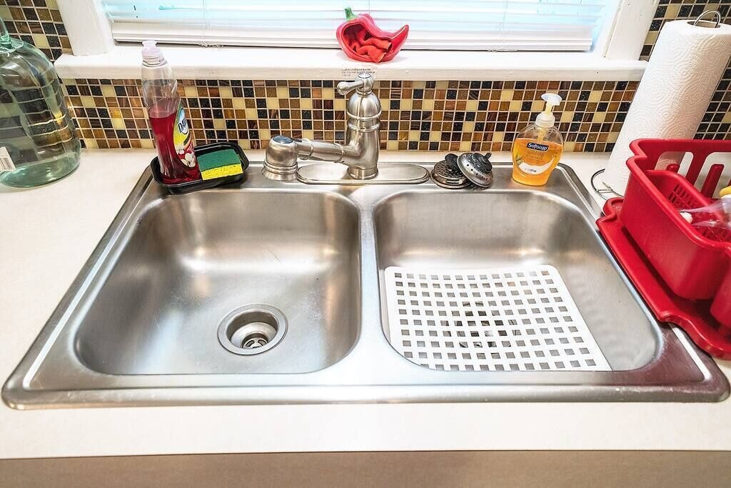 Stainless double sinks with a view of the backyard.