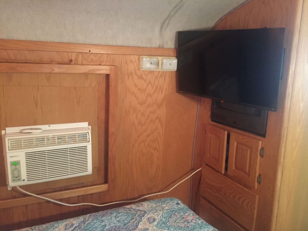 A/C Unit right by the bed & Smart TV.