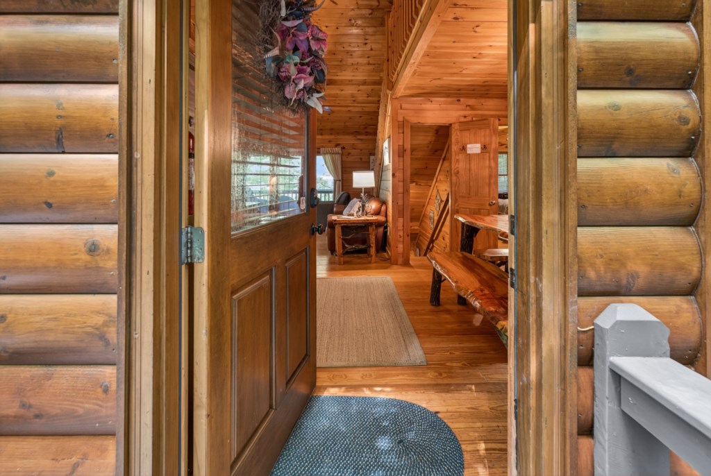Charming log cabin entrance with rustic wood interior and cozy seating area.