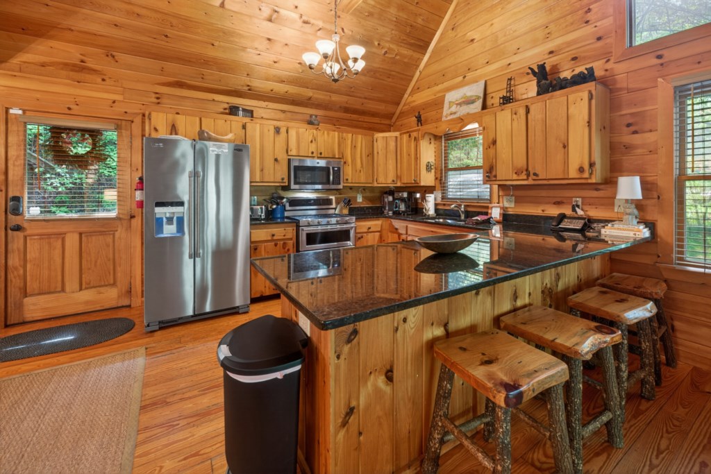 Rustic kitchen with granite countertops and stainless steel appliances, perfect for cozy cabin meals.