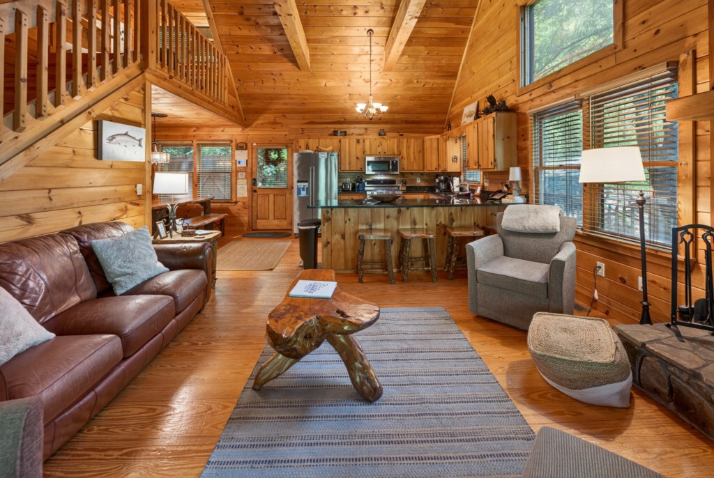 Rustic open-concept living area with cozy seating and a fully equipped kitchen.