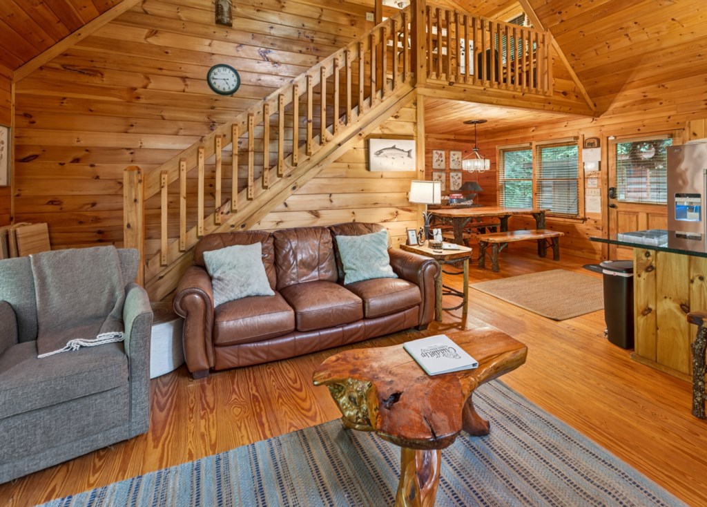 Cozy cabin living area with rustic wood accents and open loft space.