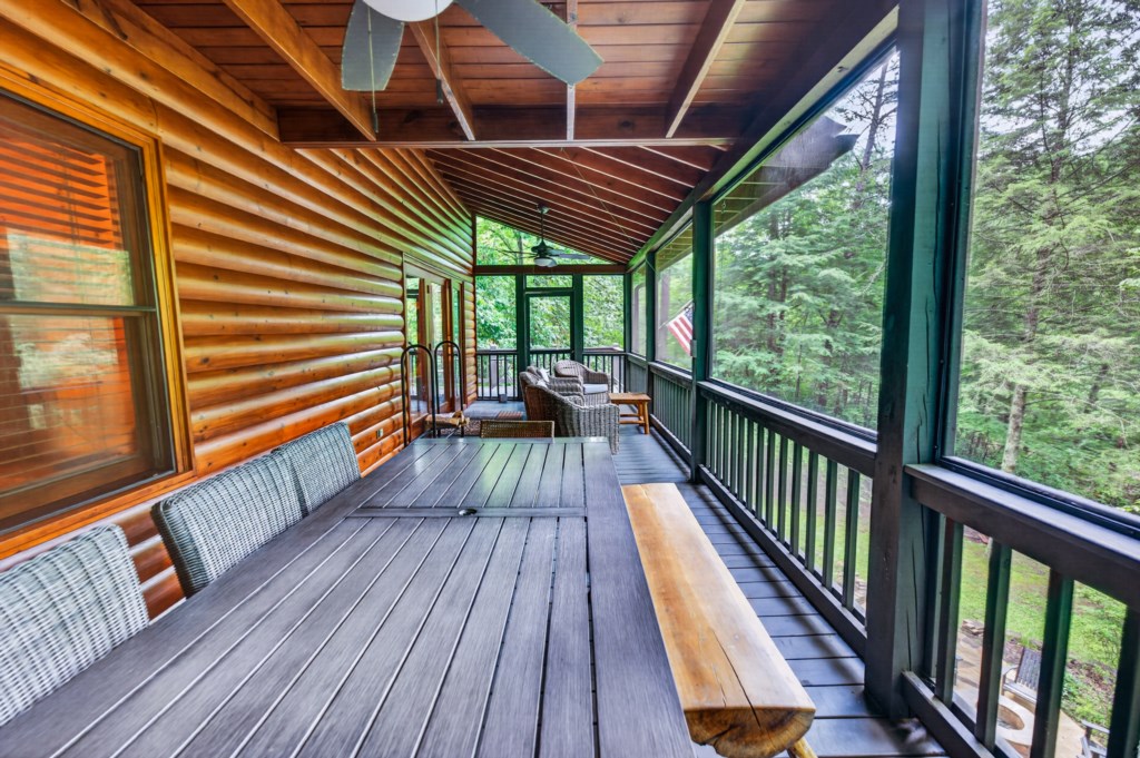 Relax on the spacious screened porch with forest views and cozy seating.