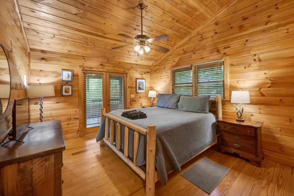 Rustic bedroom with wooden walls and a cozy king-size bed, perfect for a mountain retreat.