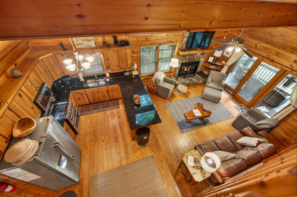 Rustic open-concept living area with cozy fireplace and fully equipped kitchen.