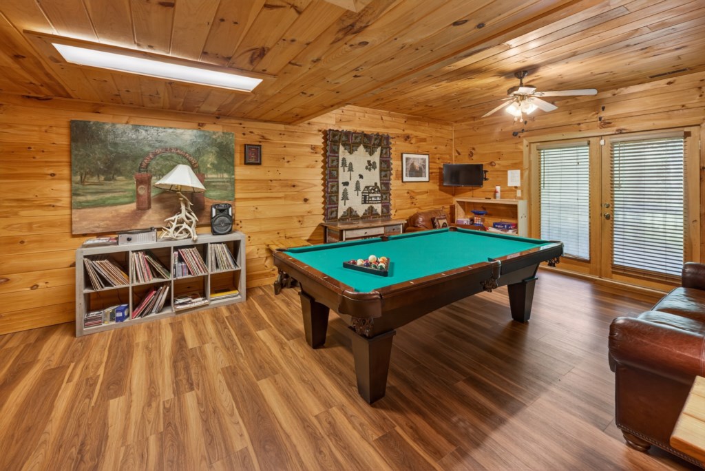 Cozy game room with a pool table and rustic wood paneling for fun evenings.