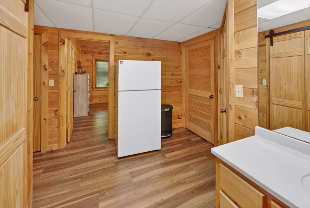 Rustic hallway with wooden paneling and a convenient fridge.