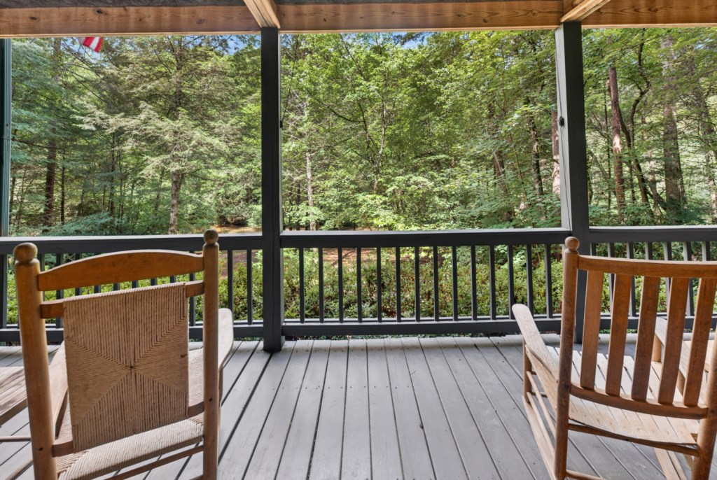 Relax on the covered deck with serene forest views.