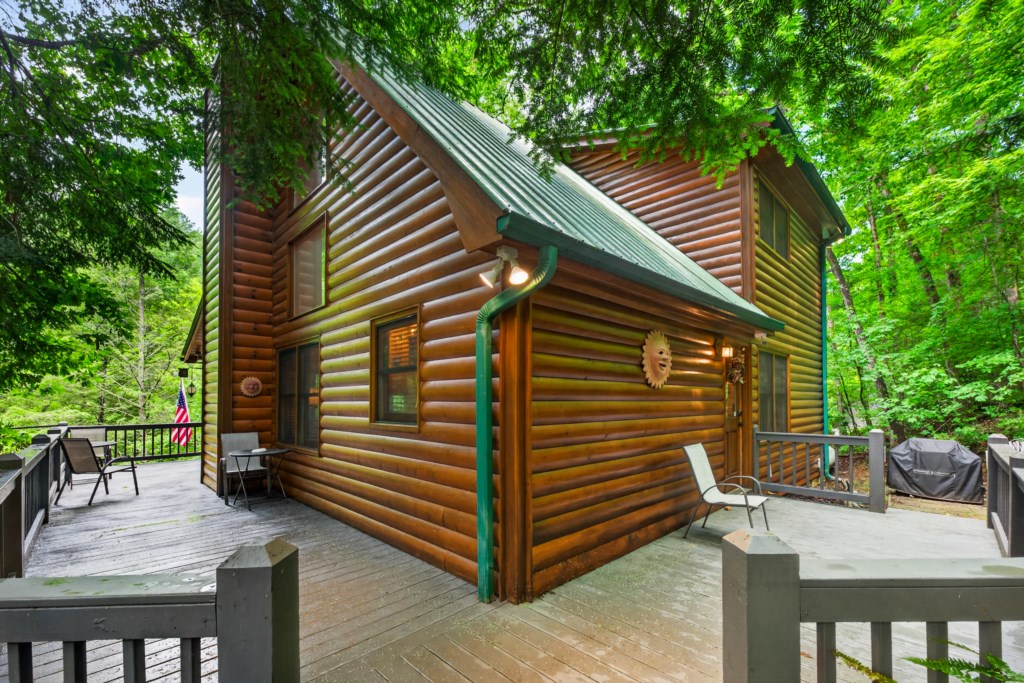 Charming log cabin with spacious deck nestled in lush forest surroundings.