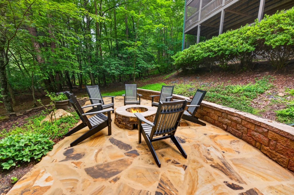 Cozy outdoor firepit area surrounded by lush greenery, perfect for evening gatherings.