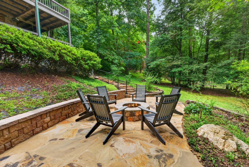 Tranquil outdoor firepit area surrounded by lush greenery, ideal for evening gatherings.