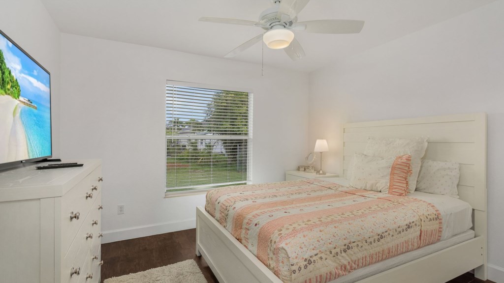 Bright bedroom with a large window offering lovely outdoor views.