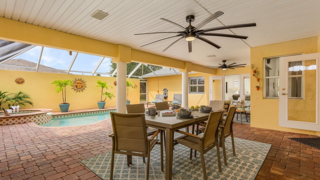 Enjoy outdoor meals by the pool in this shaded, cozy dining space.