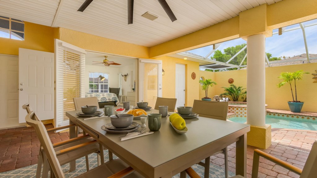 Outdoor dining area overlooking the pool, perfect for meals in the fresh air.