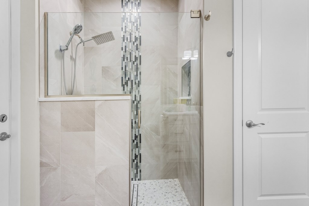 Walk-in shower with elegant tile work and a spa-like atmosphere.