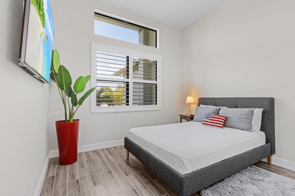 Bright bedroom with natural light, lush décor, and a serene atmosphere.