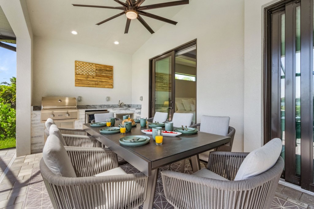 Spacious outdoor dining area with ceiling fan, perfect for al fresco meals and gatherings.