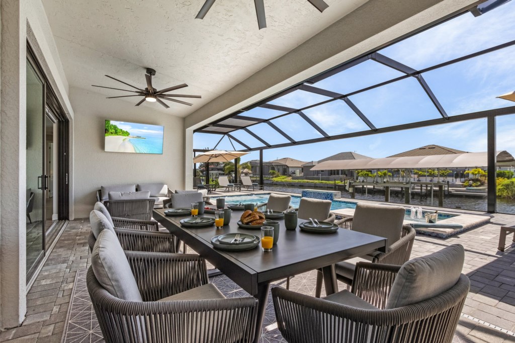 Enjoy outdoor dining with stunning canal views in a spacious, covered patio area.